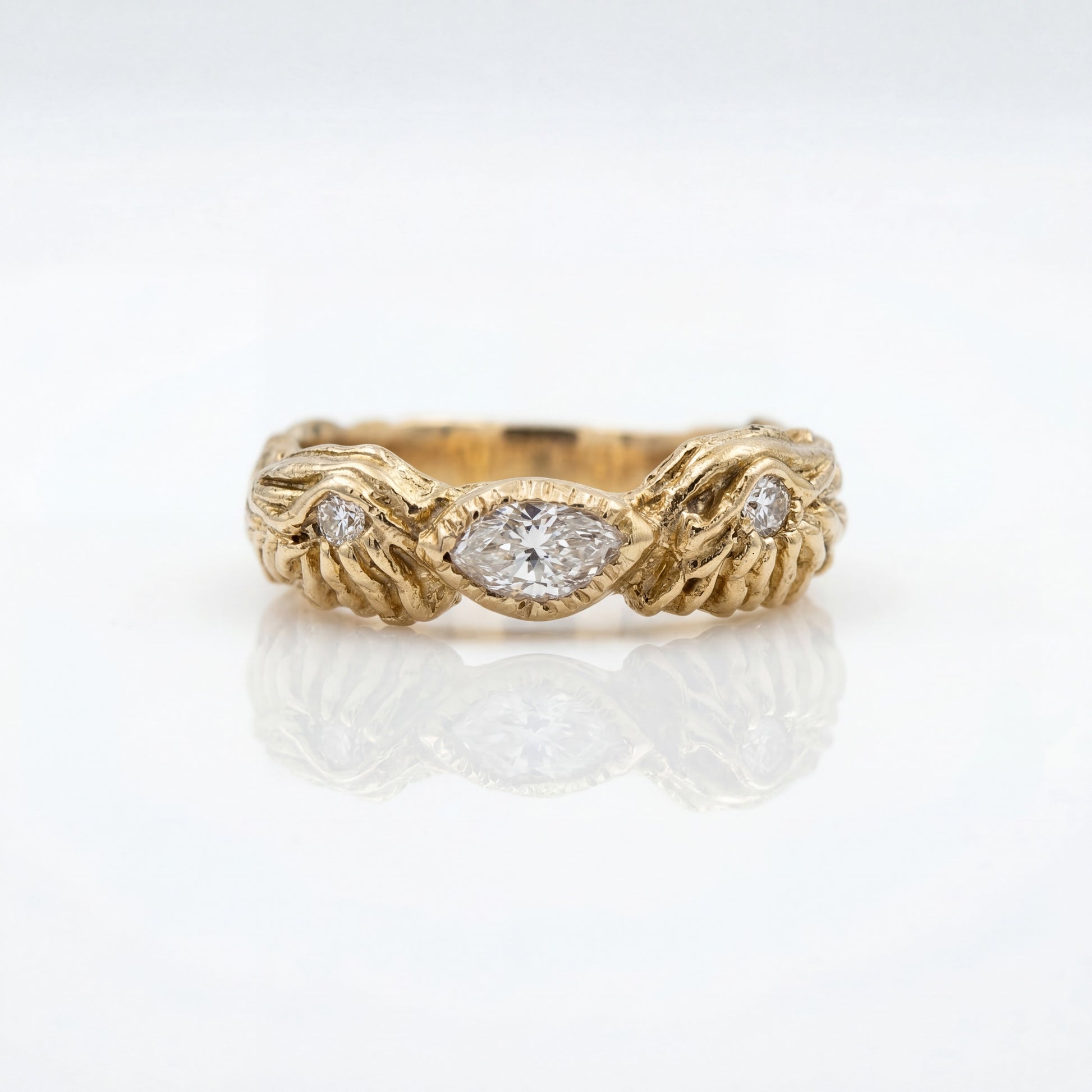 Gold ring with diamond accents on a white background