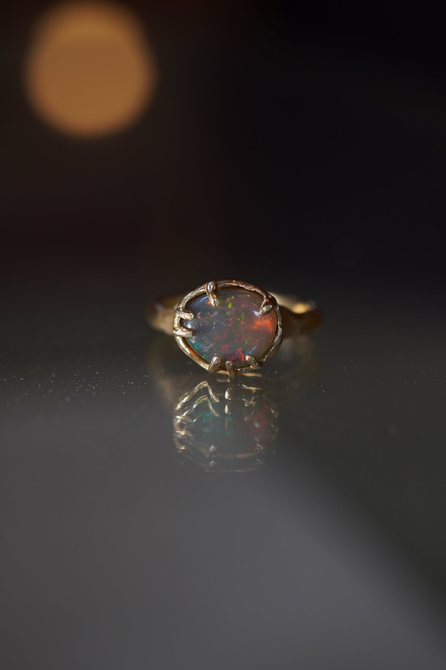 Opal ring with gold setting on a dark background