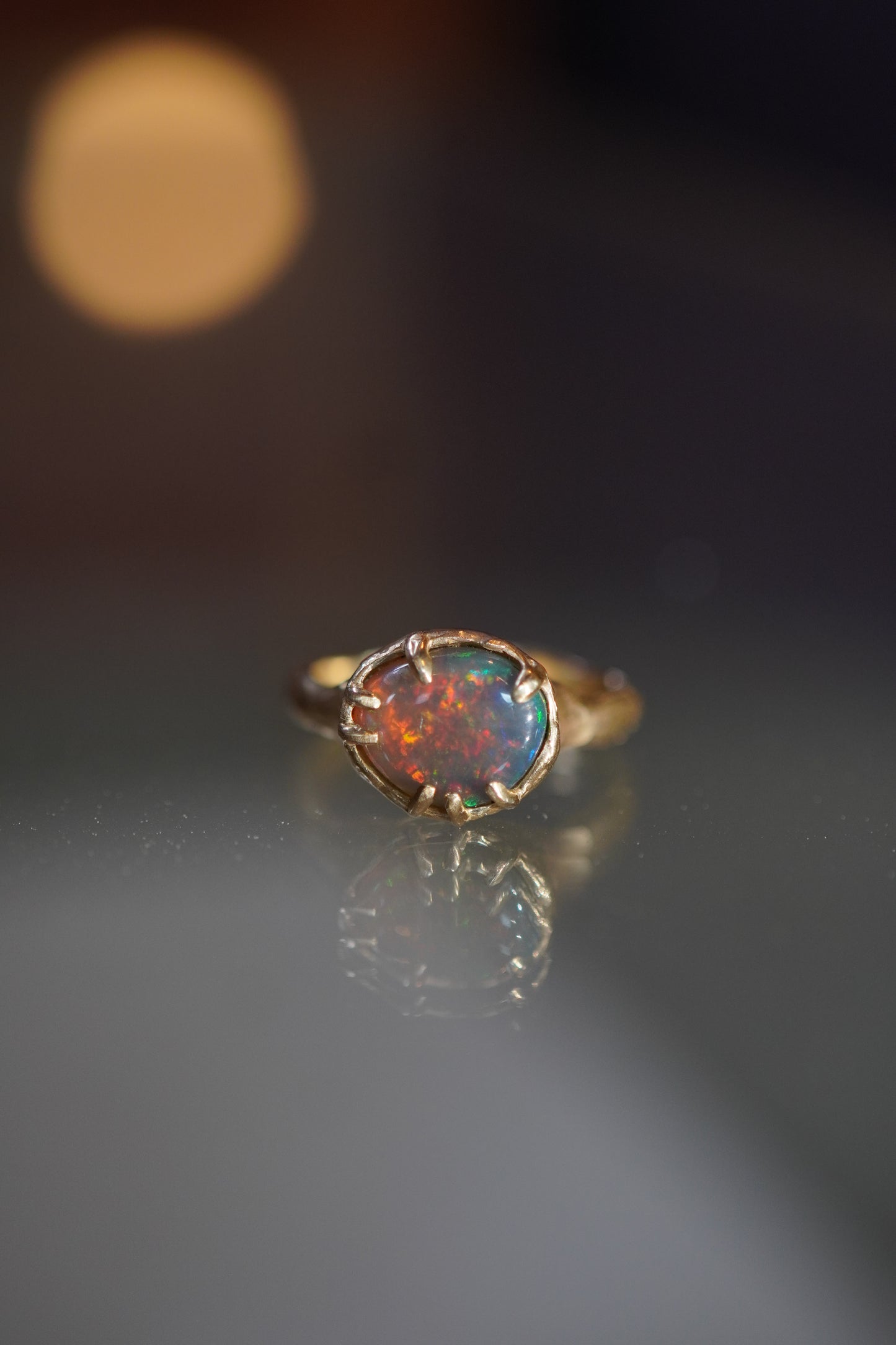 Opal ring with gold setting on a dark background