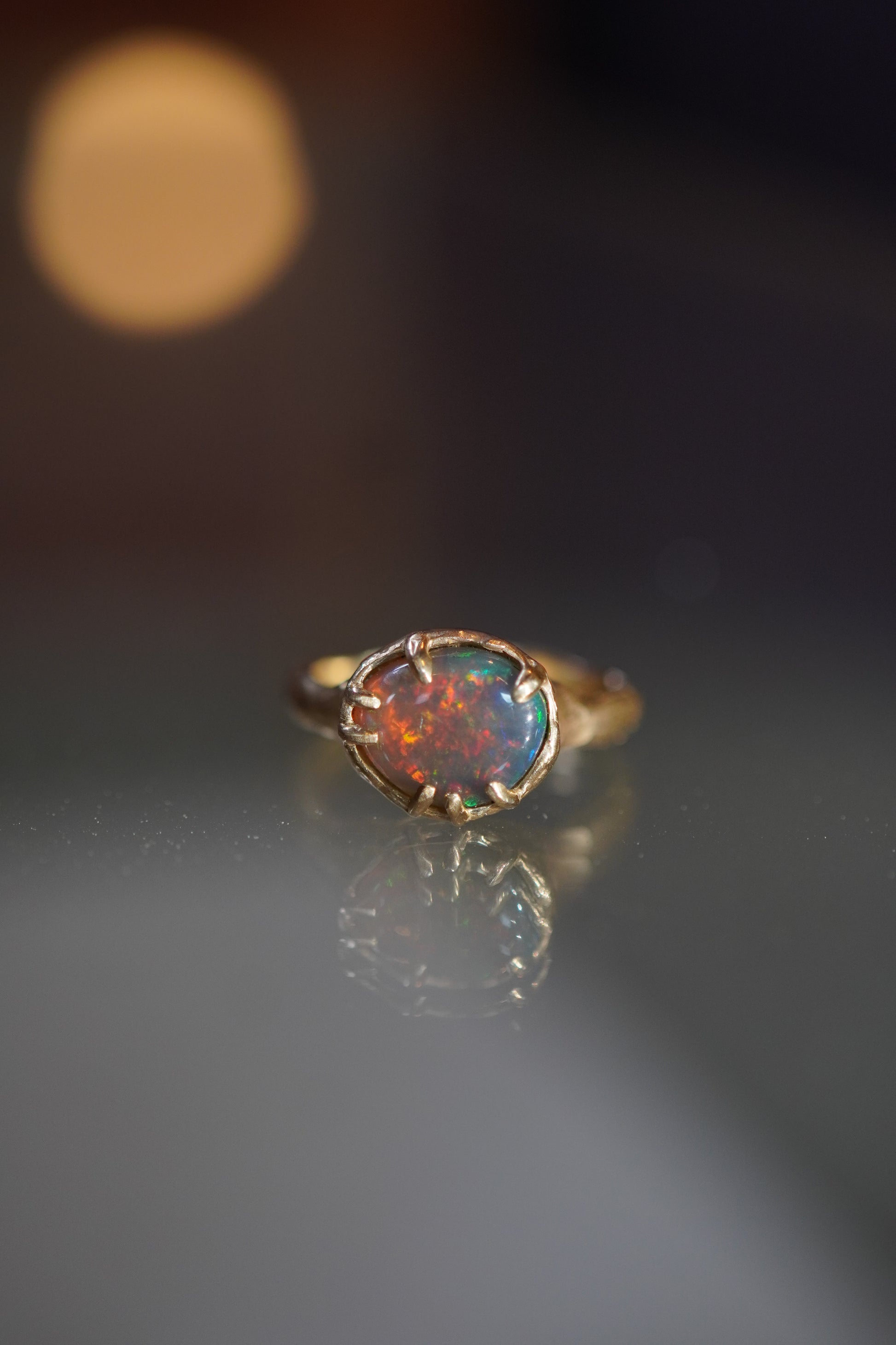 Opal ring with gold setting on a dark background
