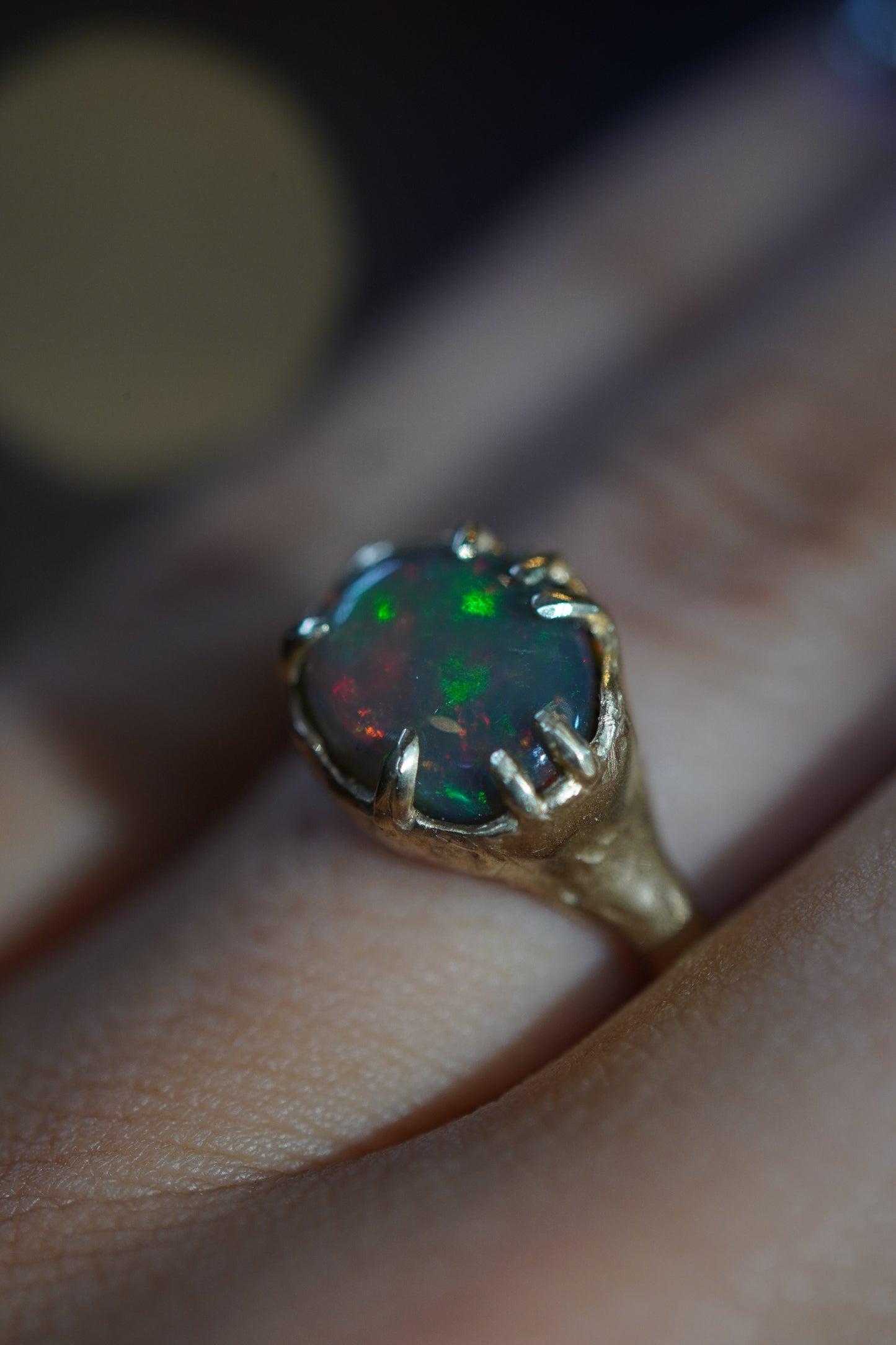Gold ring with a colorful gemstone on a finger