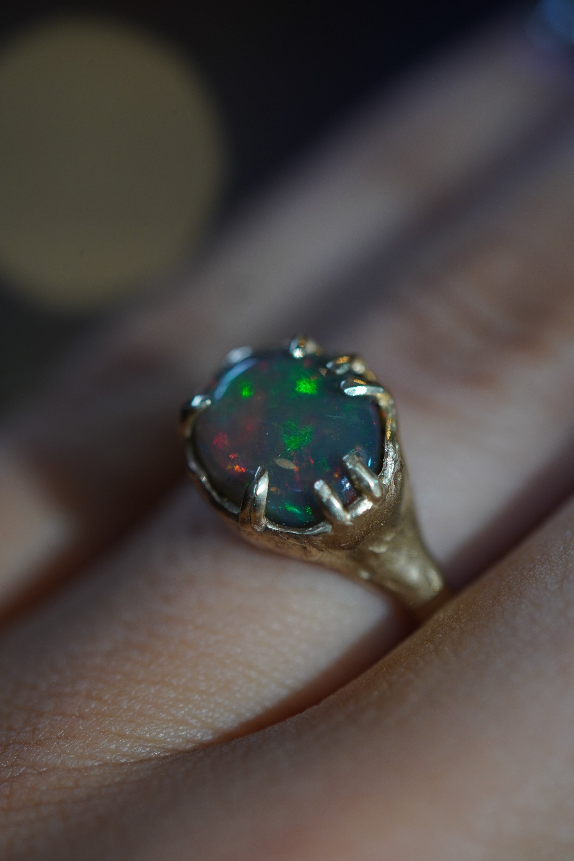 Gold ring with a colorful gemstone on a finger