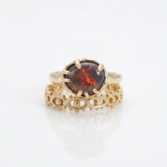 Gold ring with a red gemstone on a white background