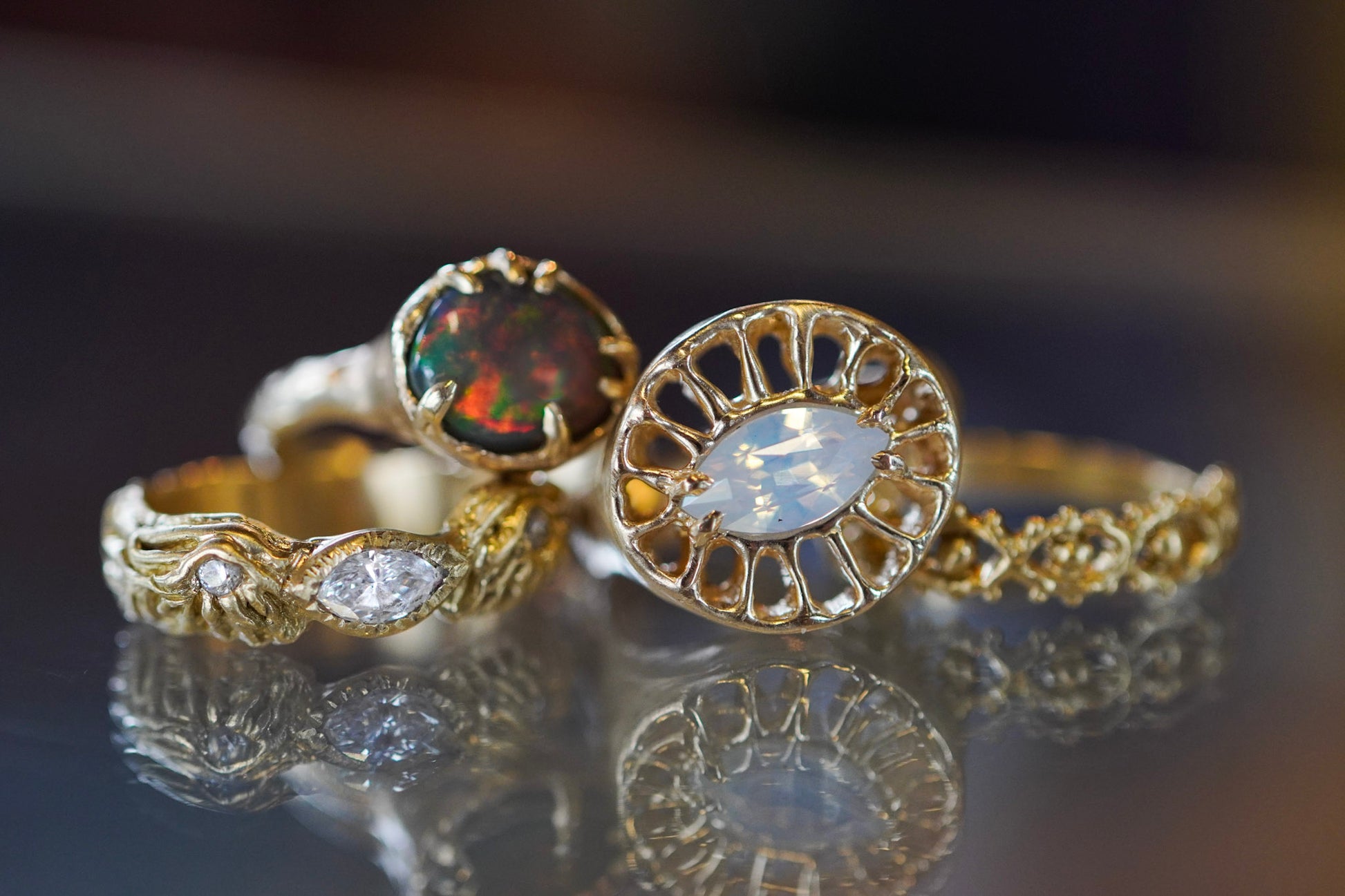 4 gold rings with various stones and blurry background
