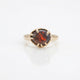 Gold ring with a red flashing opal on a white background